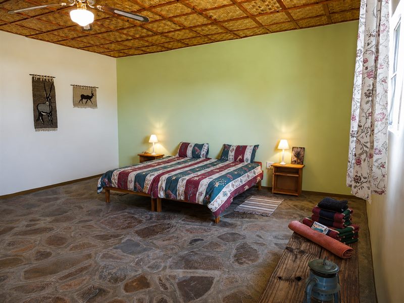 Doppelbett mit Wandbehängen und Rohrdecke im Bungalow